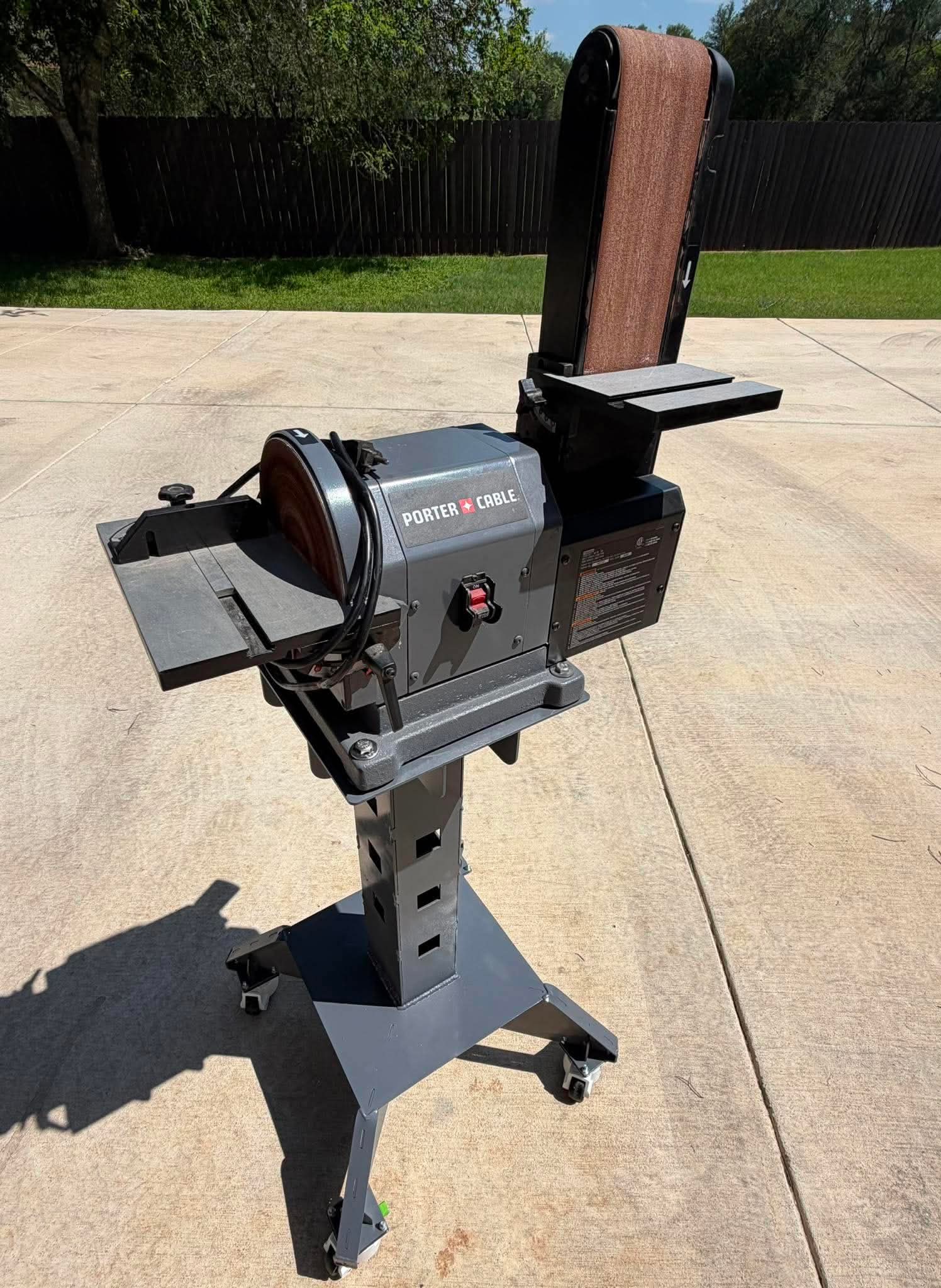 Powder-coated rolling steel tool stand with a customer's belt and disc sander mounted on top.