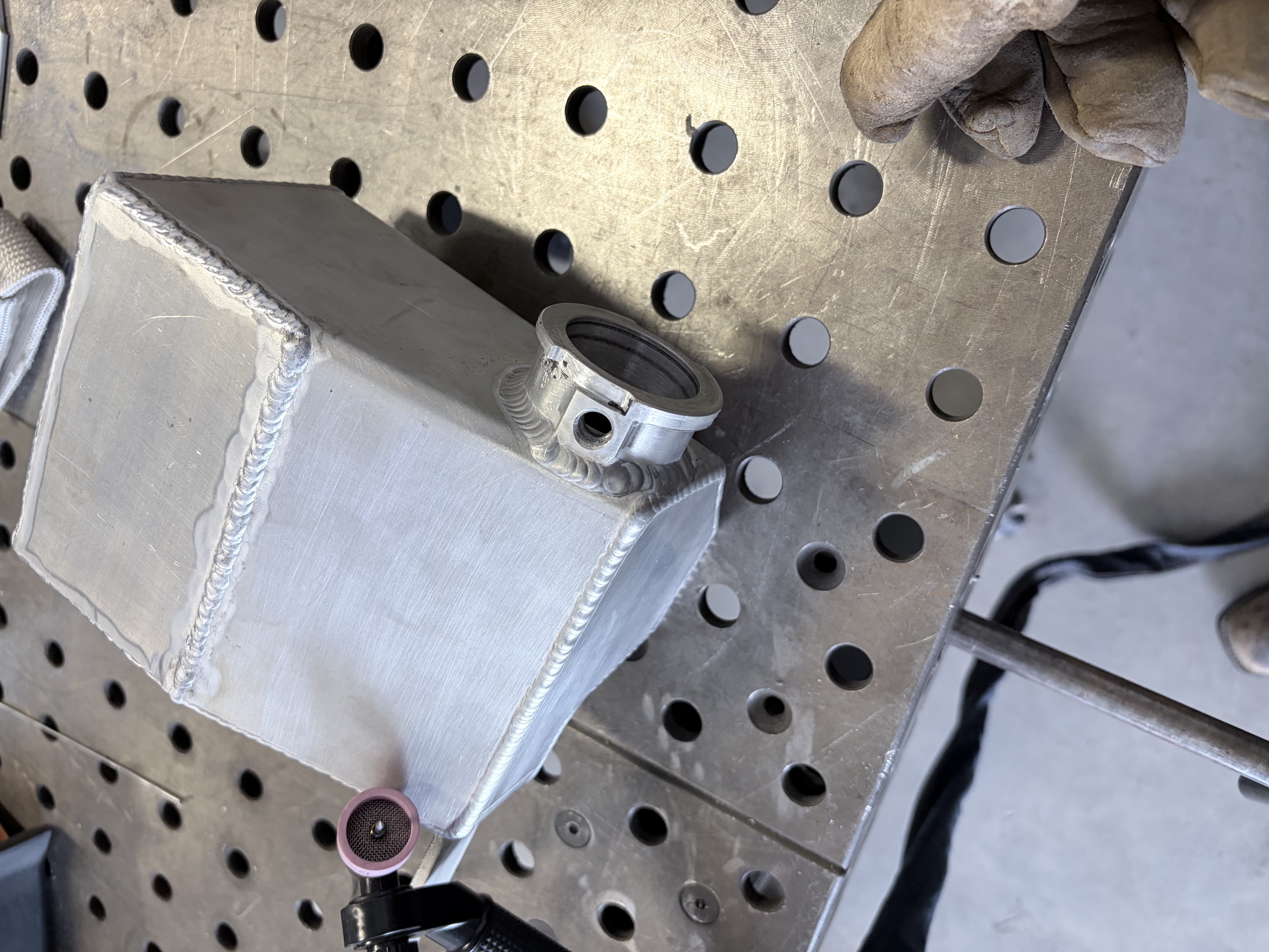Modified aluminum coolant tank with a TIG-welded fitting boss.