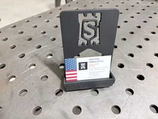 CNC plasma cut metal part on a welding table with clean cut edges and hole placement.