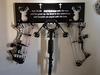 Custom wall-mounted bow hanger with laser-engraved panel and compound bows.