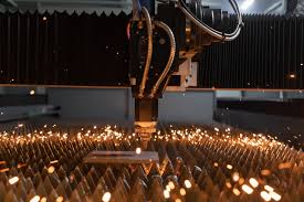 Fiber laser cutting head cutting precision parts from a metal sheet.