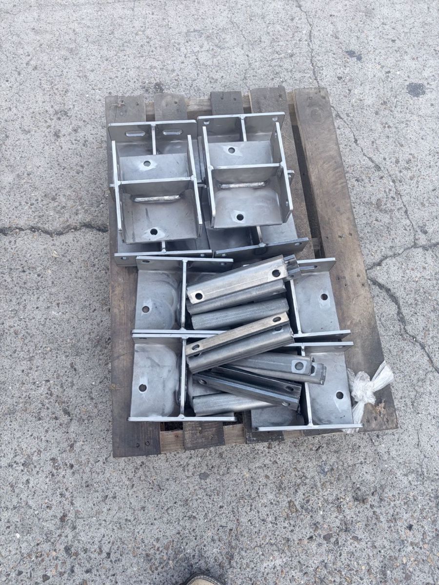 Palletized batch of welded steel brackets and channel parts ready for delivery.
