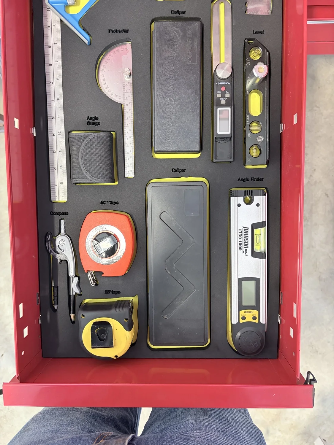 Finished custom foam insert loaded with measuring tools in a red toolbox drawer.